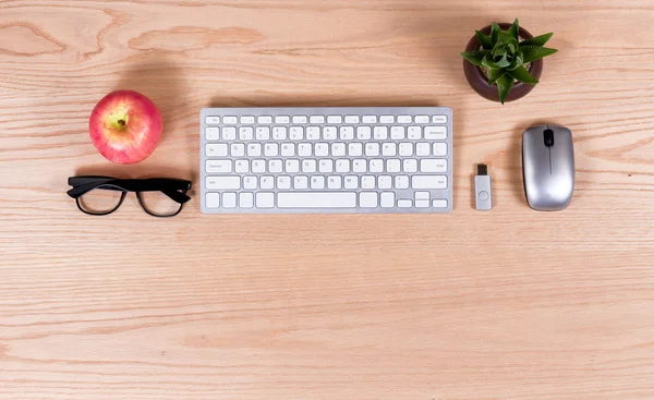 Overhead view of office oak desktop with modern peripherals