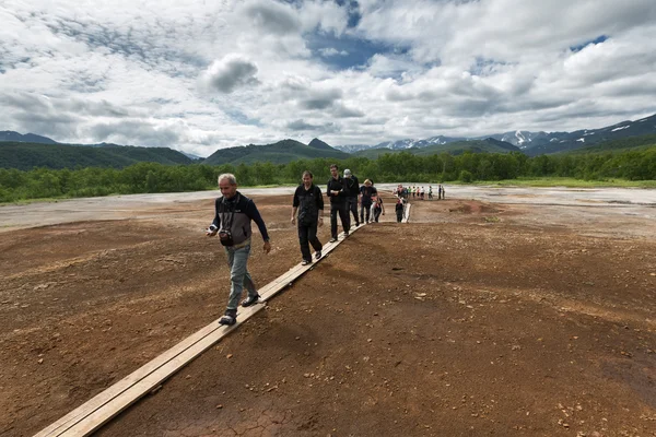 Tourists walk on Travertine Shield Boiler. Russia, Kamchatka, Nalychevo