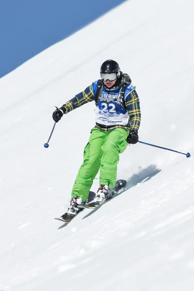 Girl skier rides steep mountains. Russia, Far East, Kamchatka