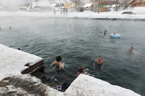People relaxing in public geothermal spa in hot spring pool