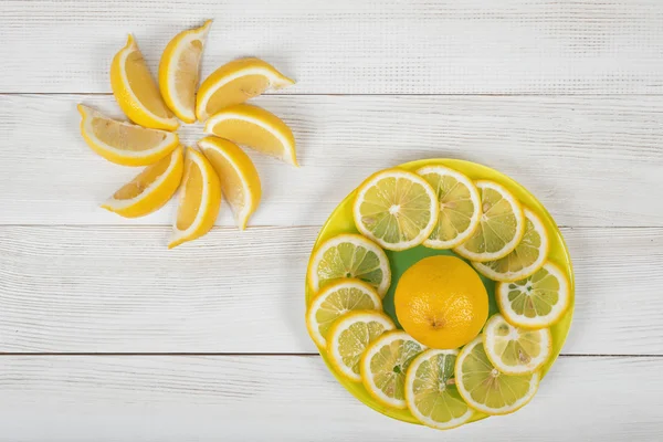 Citrus fruit slices arranged into revolving shape and decorated on a plate in top view.