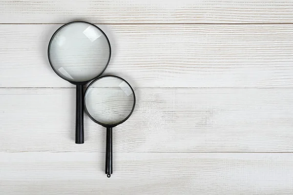 Magnifying glasses lying on a wooden surface