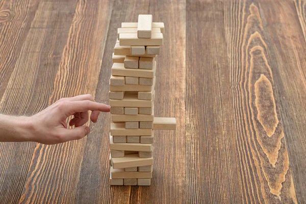 Close-up hands of man playing with wooden blocks