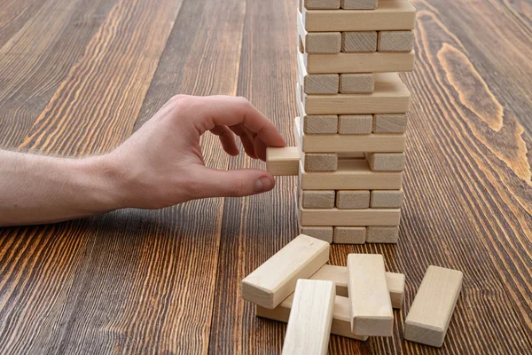 Close-up hands of man playing with wooden bricks
