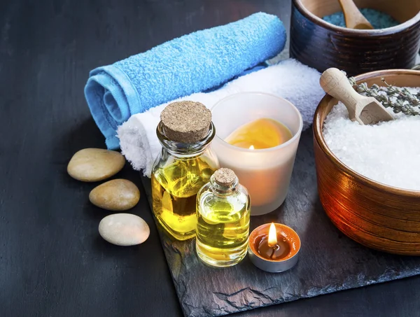 Spa setting with body oils, towels ,bath salt and candles