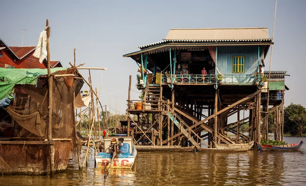 Unidentified people ride a boat in floating village