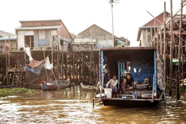 Unidentified people ride a boat in floating village