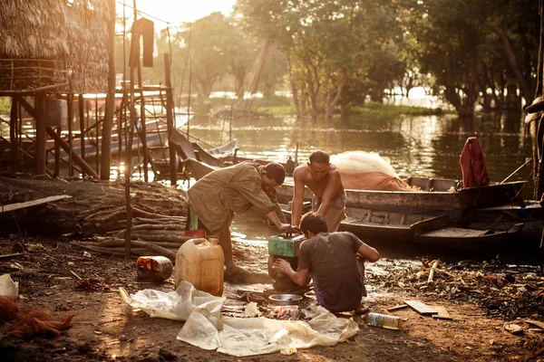 Unidentified khmer people repair their bot on Tonle Sap lake.