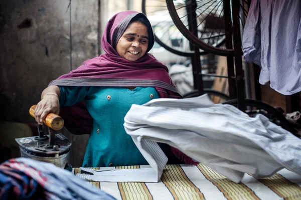 Indian woman ironing clothes in Delhi