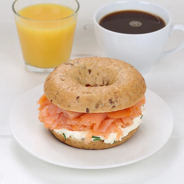 Bagel for breakfast with salmon fish, orange juice and coffee