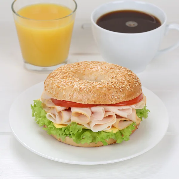 Bagel for breakfast with ham, orange juice and coffee