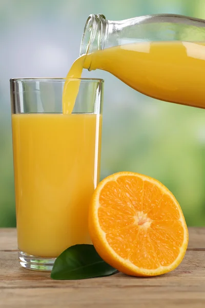 Orange juice pouring from oranges fruits