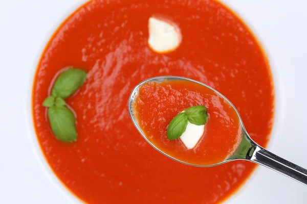 Eating tomato soup meal with fresh tomatoes on spoon from above