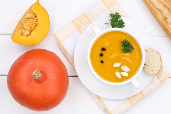 Pumpkin soup with pumpkins in bowl from above