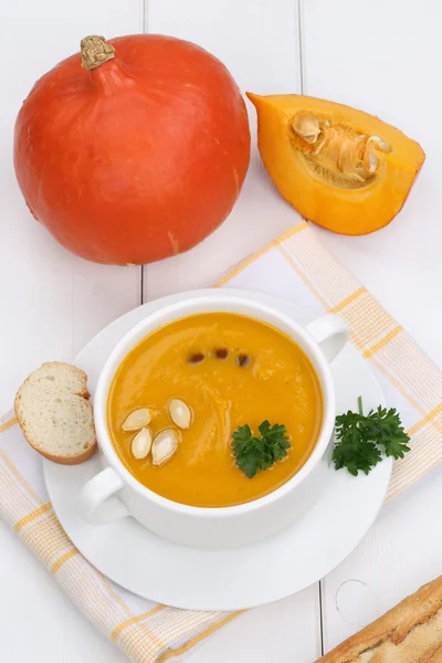 Pumpkin soup with baguette in cup