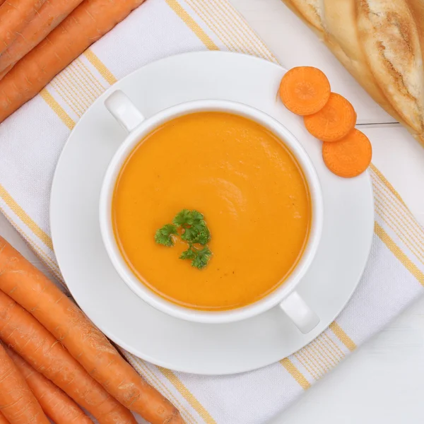 Carrot soup with carrots in bowl from above healthy eating