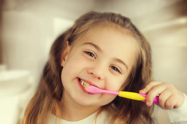 Cute little girl washing teeth