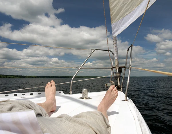 Bare foot of a man who is lying on the deck of the yacht