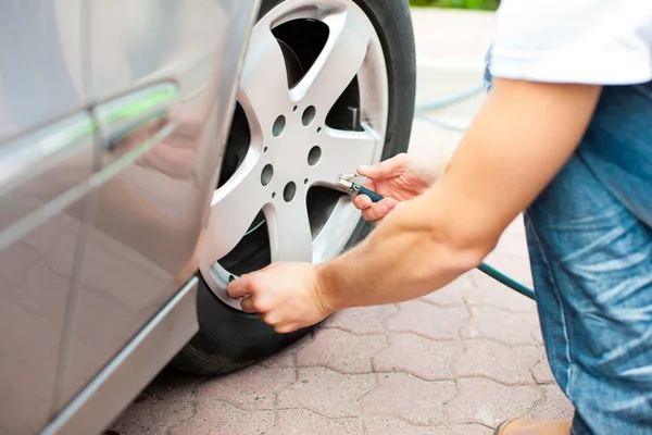 Man is controlling the tire pressure of car