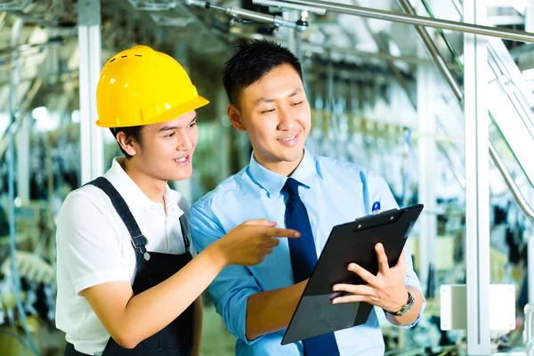 Worker and production manager with Clipboard