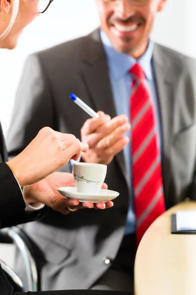 Businesspeople in business office drink coffee