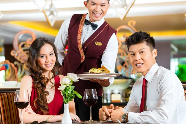 Waiter serving dinner in elegant restaurant