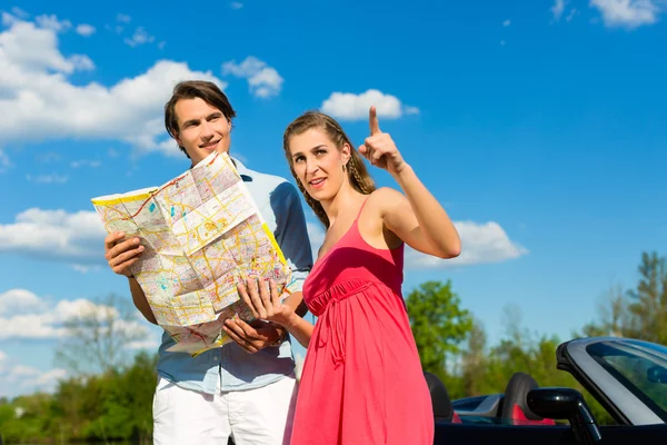 Young couple with cabriolet in summer on day trip