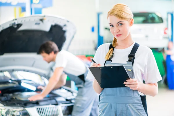 Mechanic team working in car workshop