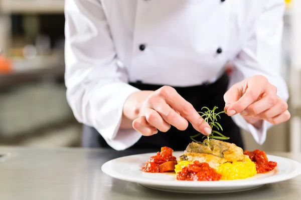 Female Chef in restaurant kitchen cooking