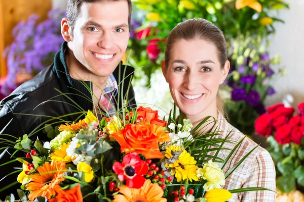 Female florist and male customer in flower shop