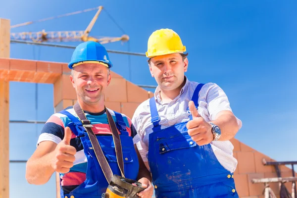 Construction site workers building walls on house