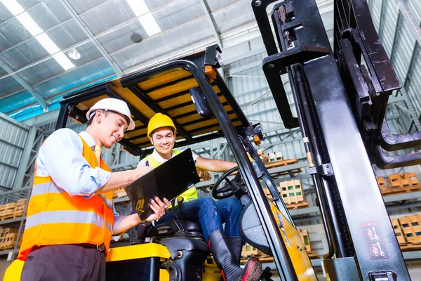 Lift truck driver and foreman in storage