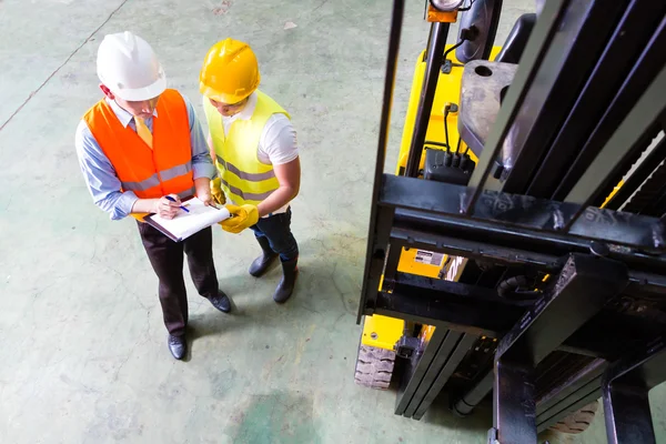 Lift truck driver and foreman in storage