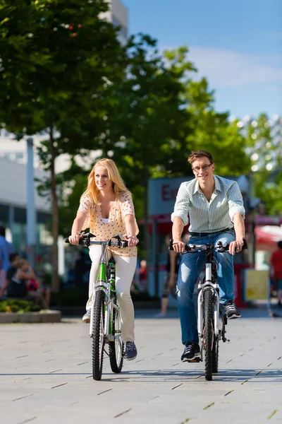 Urban couple riding bike in city