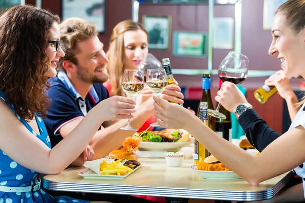 Friends eating and drinking in fast food diner