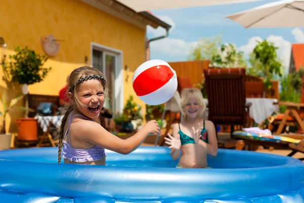 Children playing with ball in water pool