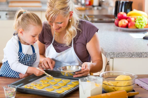 Mother and daughter baking cookies together