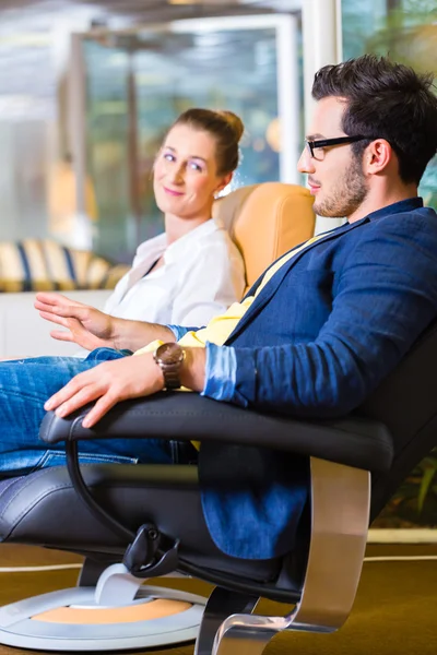 Couple buying armchair in furniture store