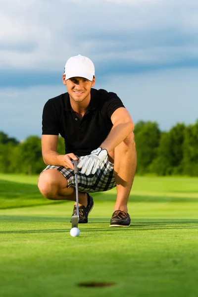 Young golf player on course putting