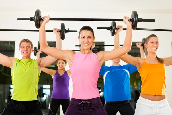 Fitness group with barbell in gym