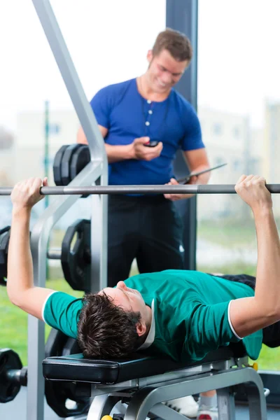 Man and Personal Trainer in gym