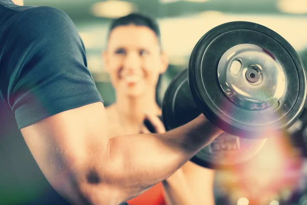 Personal Trainer in gym and dumbbell training