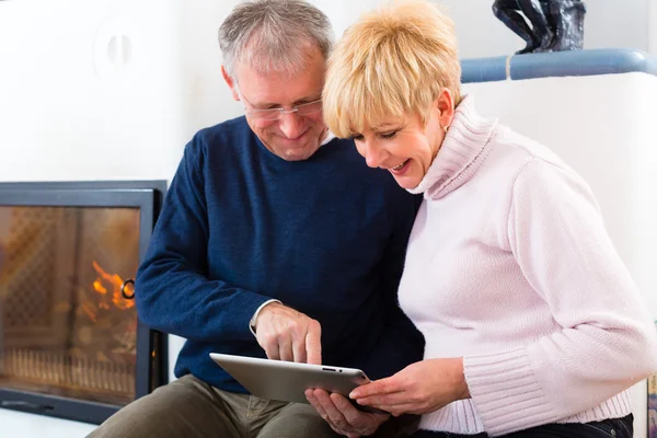 Seniors at home in front of fireplace