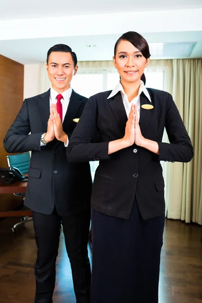 Asian hotel staff greeting with hands put together