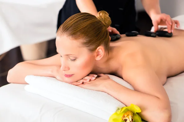 Woman having wellness spa hot stone massage