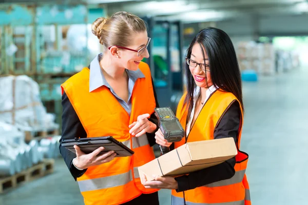 Workers with package in warehouse of forwarding