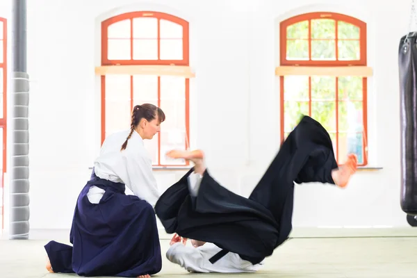 Aikido teacher and student training throwing and falling