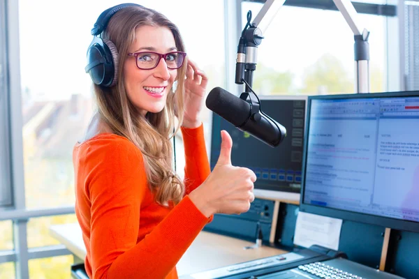 Female radio presenter in radio station on air