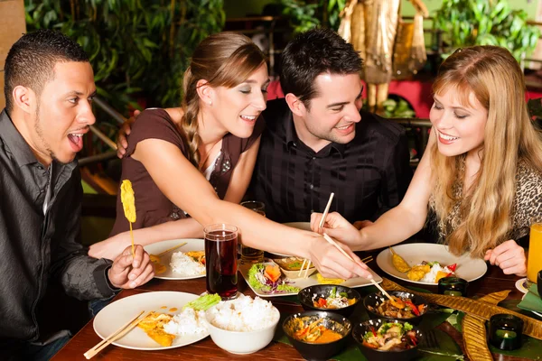 Young people eating in Thai restaurant