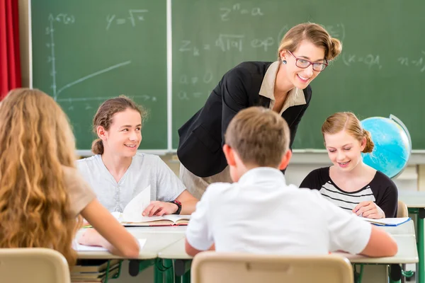 Teacher teaching students  geography lessons in school